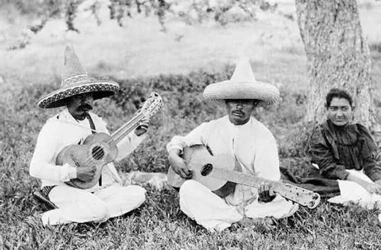 Những người đàn ông đánh đàn guitar trên bãi đất cỏ. Ảnh chụp năm 1923. Đây là một trong những bức ảnh đen trắng hiếm hoi chụp  cuộc sống thế giới của tay ảnh nổi tiếng này. Ảnh ATI